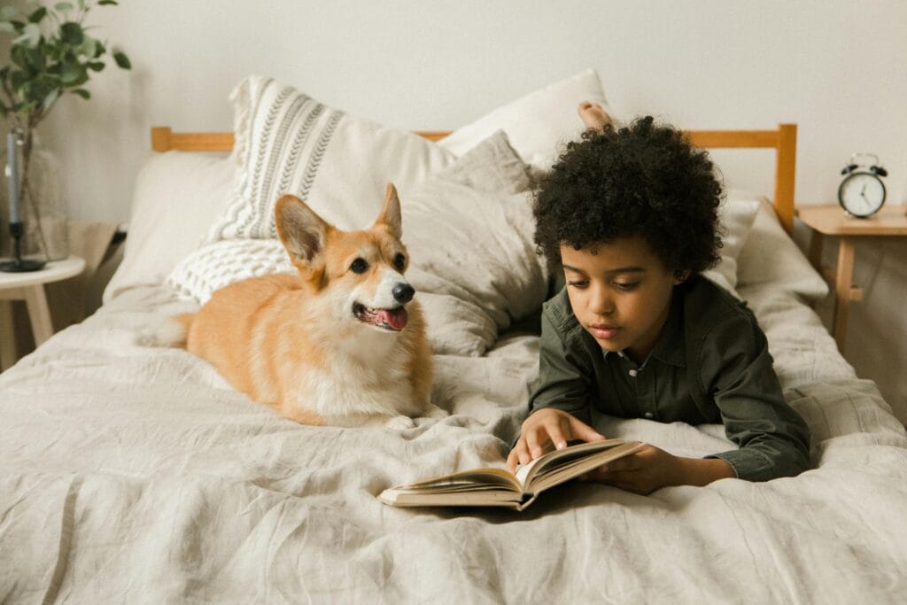 Barn og hund i samspill – barn som leser bok sammen med hund i rolig og trygg situasjon