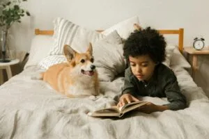 Barn og hund i samspill – barn som leser bok sammen med hund i rolig og trygg situasjon